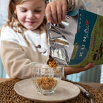 Cereal Manzana Canela de Kuna Foods, cereal infantil sin leche, con envase plateado y fondo azul