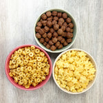 Mix Cereales Kuna Foods cereales sin azúcar añadida y sin gluten en boles de colores sobre mesa clara